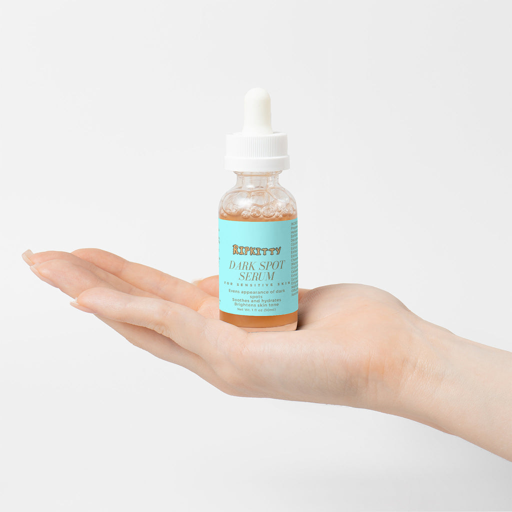 Hand holding a bottle of 'Kieffey' dark spot serum against a light background