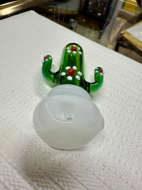 Ripkitty 4.5" cactus borosilicate glass spoon pipe — green sculpted saguaro cactus body with raised white dot nodules and red glass bead accents, large milky white opal bowl, shown on white surface with mirror tray background