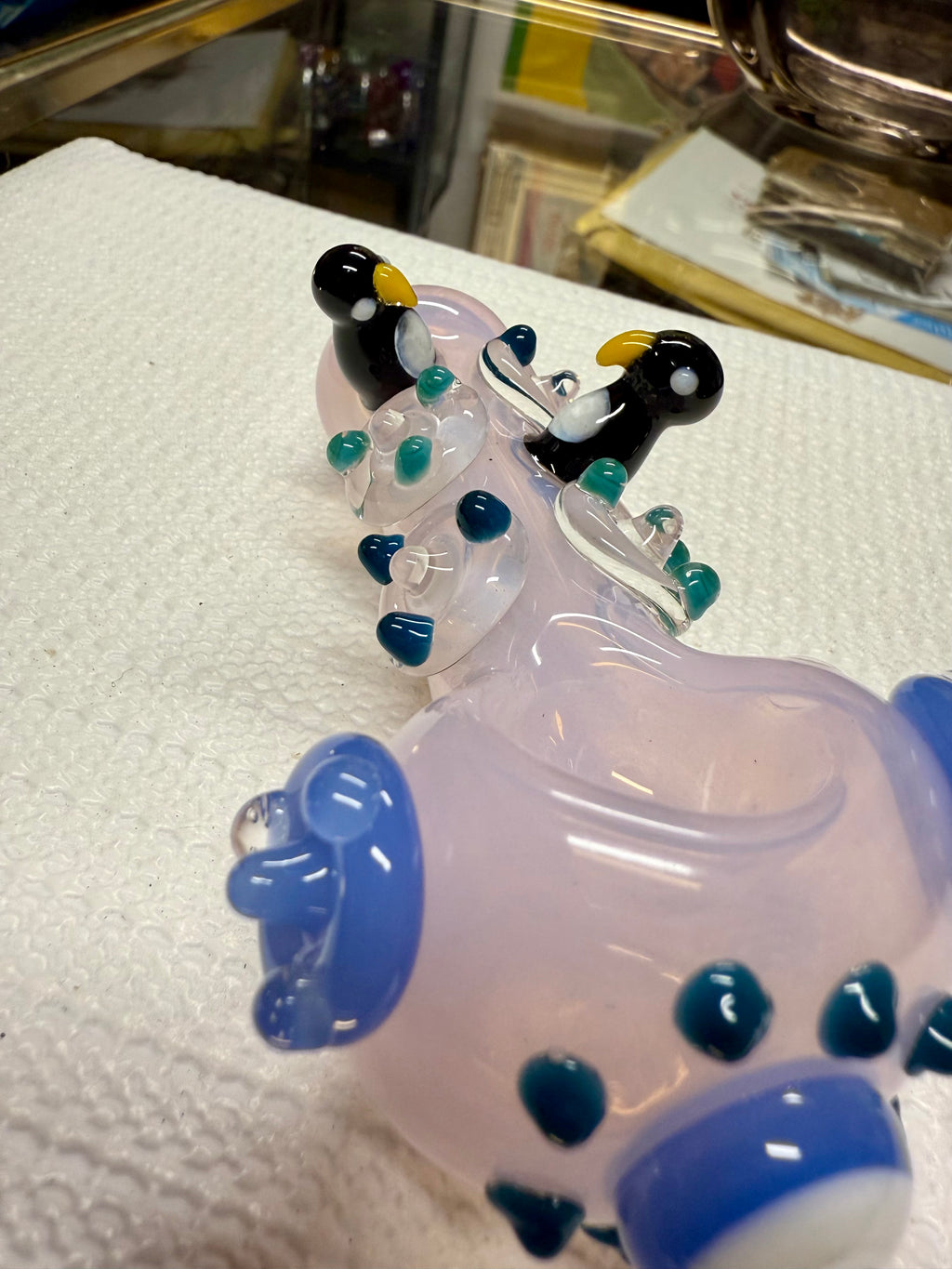 Ripkitty 4.5" penguin art glass pipe — angled view of pink body with penguin sculpts, flipper side accents, and evil eye bowl