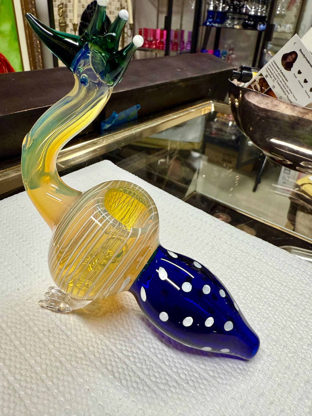 Ripkitty 5" peacock pipe — top-down view showing amber beak mouthpiece, crest prongs, and teal-striped body from above