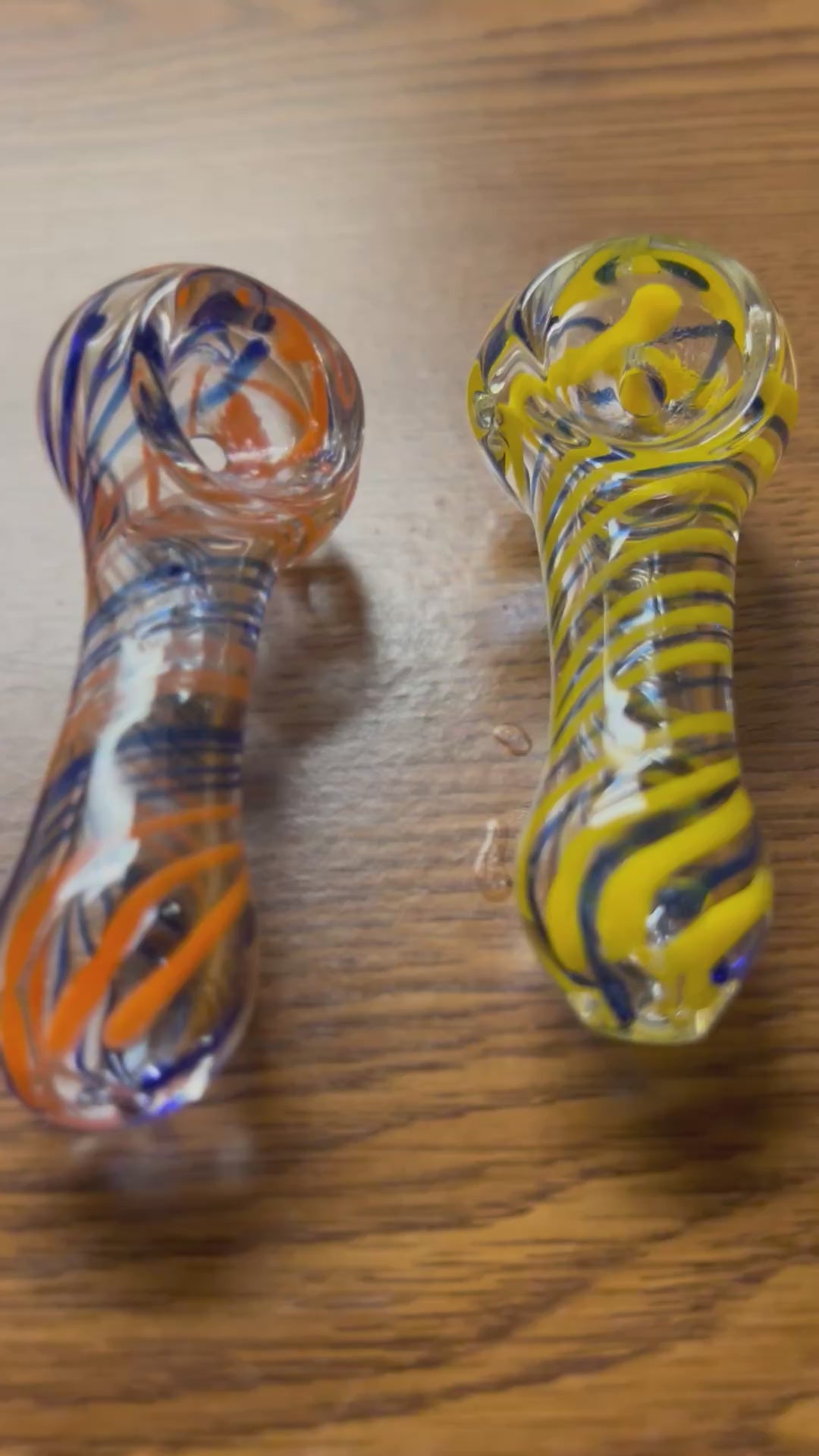 Ripkitty 3" striped swirly handblown borosilicate glass spoon pipe — 360° display video showing orange and navy blue and yellow and navy blue spiral stripe colorways, rounded bowl with carb, tight helical stripe pattern across full body, and chunky mouthpiece end