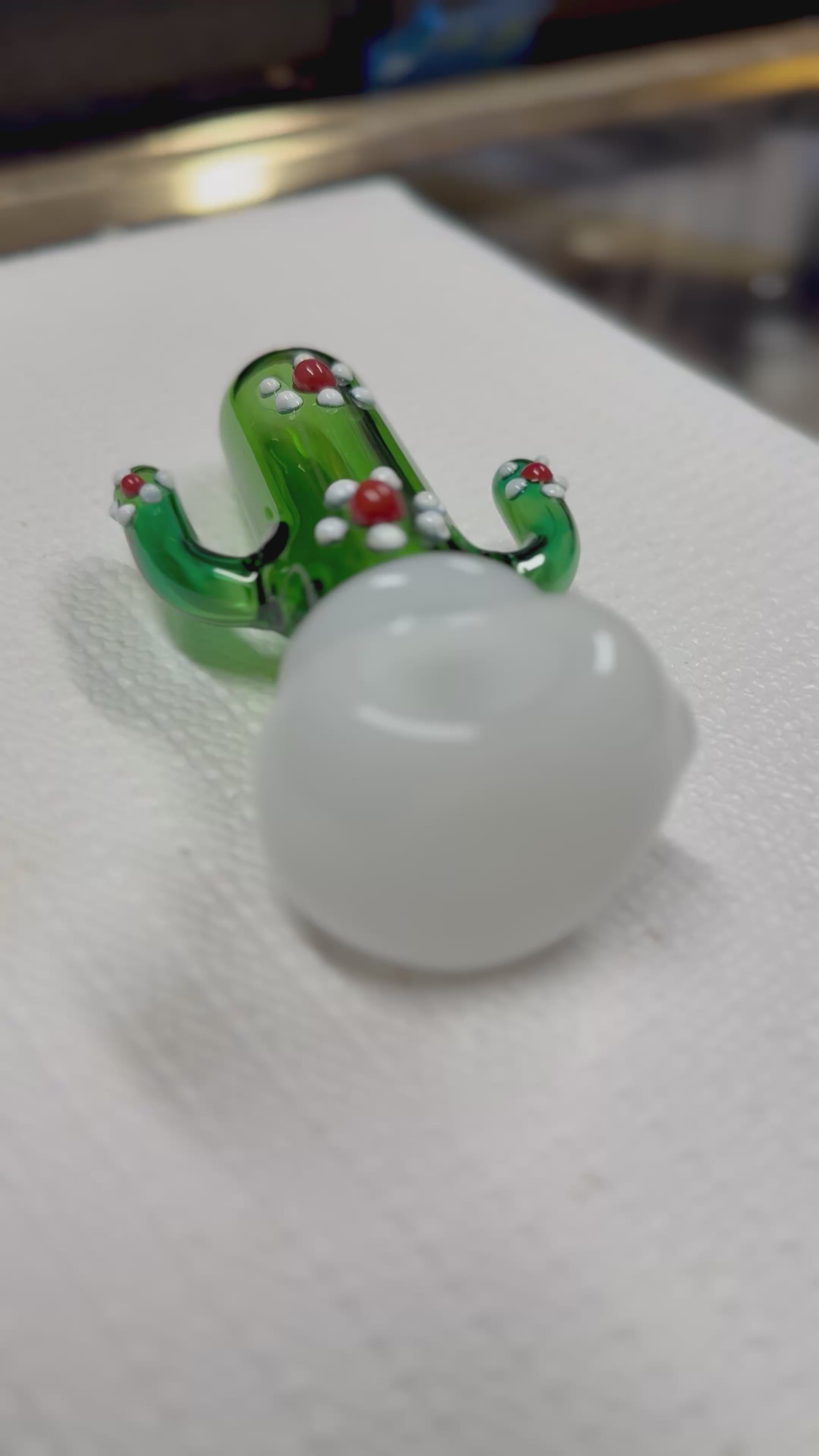 Ripkitty 4.5" cactus borosilicate glass spoon pipe — 360° display video showing green sculpted saguaro cactus body, raised white dot nodules, red glass bead